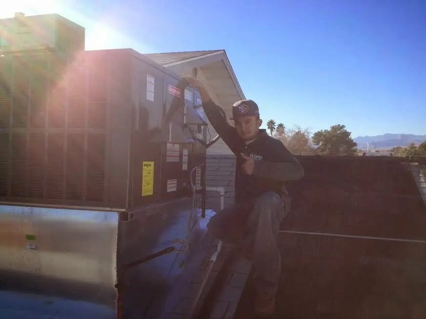HVAC technician performing Heat Pump Repair on a rooftop unit in Yuma